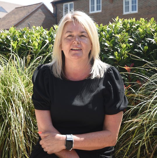 Portrait of Margaret, a Bargate Homes team member, smiling outdoors in front of garden foliage