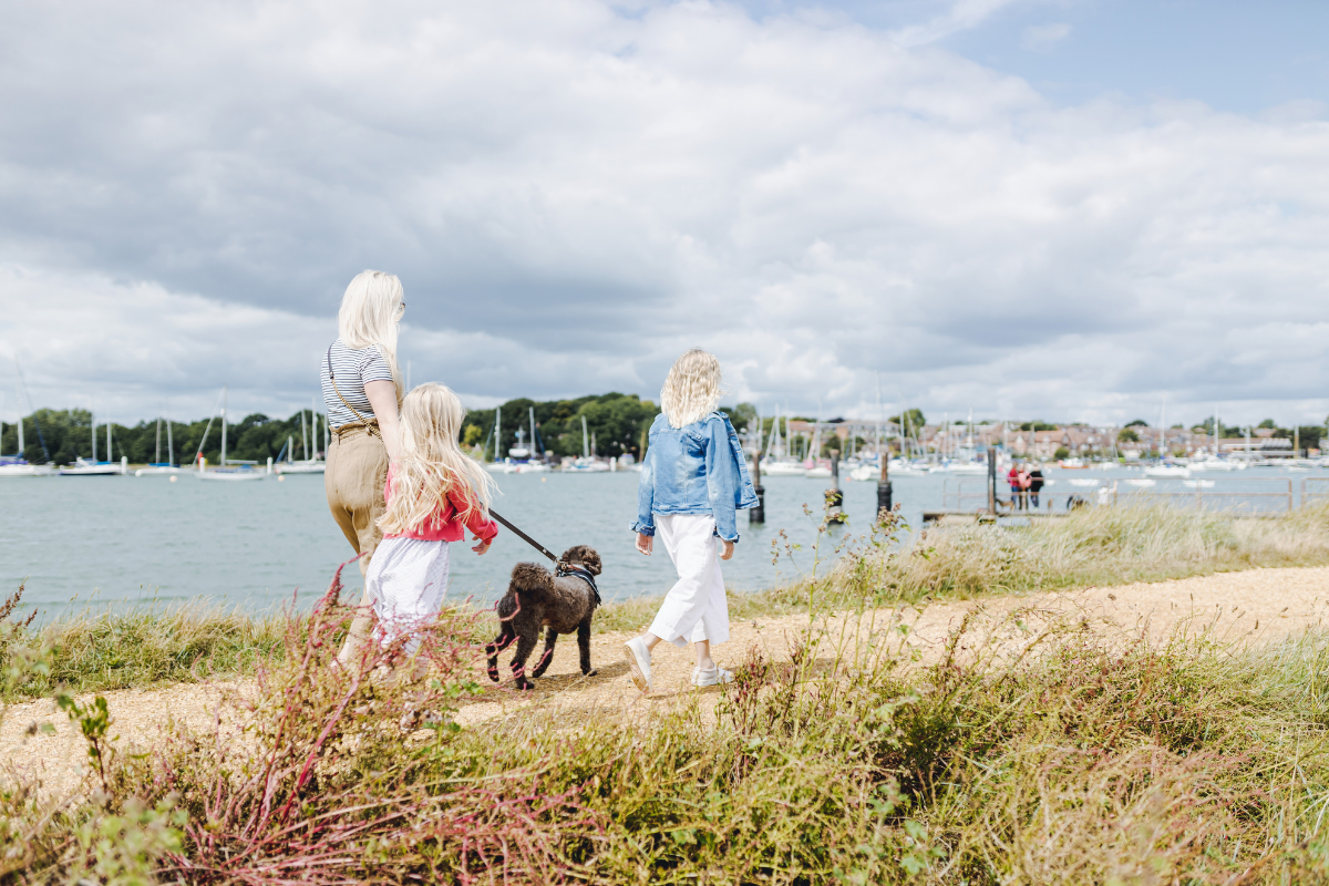 Woman walking her dog with her children along the coast at Warsash